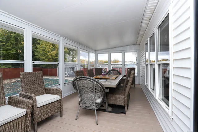 a dining room with furniture a floor to ceiling window and wooden floor