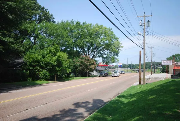 a view of a road with a bench in the background
