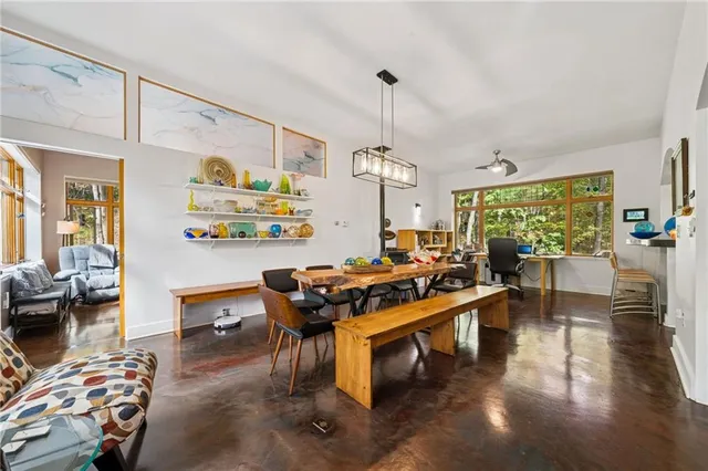 a room with furniture pool table and large windows