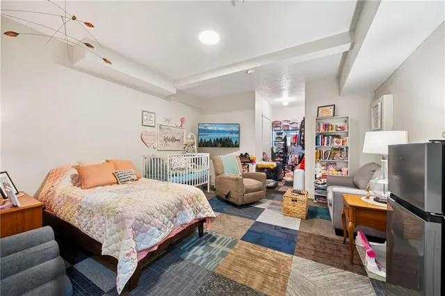 a bedroom with a bed a couch and bookshelf