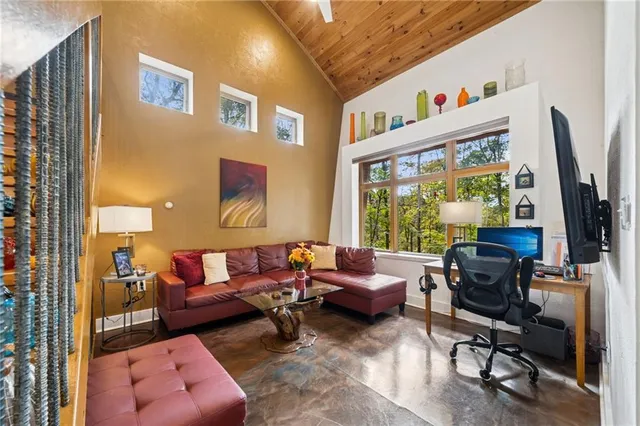 a living room with furniture a flat screen tv and a floor to ceiling window