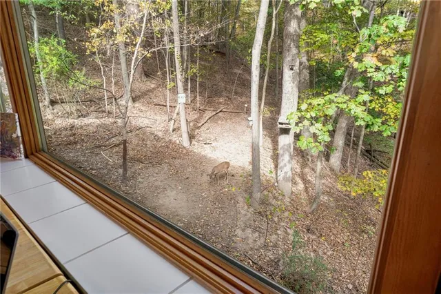 a living room with furniture floor to ceiling window and a flat screen tv