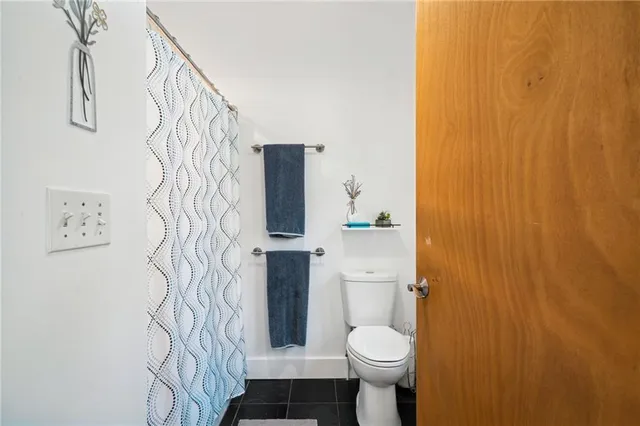 a bathroom with a toilet and shower curtain