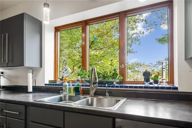 a view of a kitchen with a sink and large window