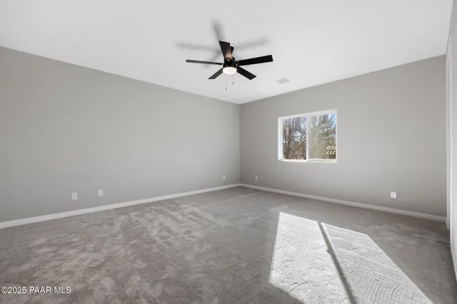 an empty room with a window and a ceiling fan