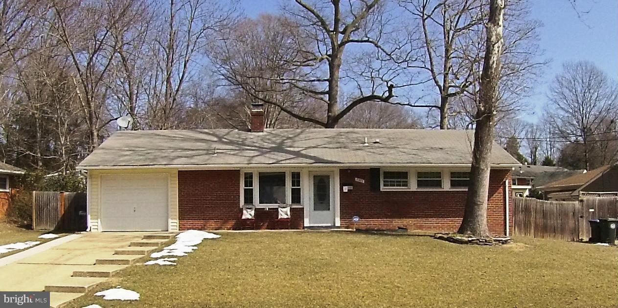 a front view of a house with a garden and trees