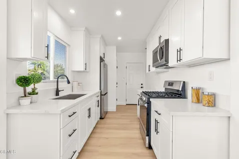 a kitchen with stainless steel appliances granite countertop a sink and a stove