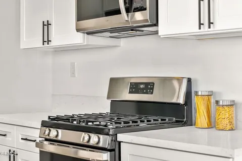 a white stove top oven sitting inside of a kitchen