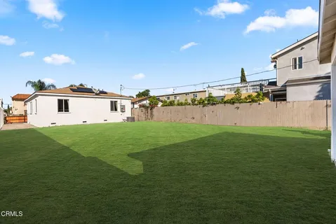 a view of a white house with a yard and a large tree
