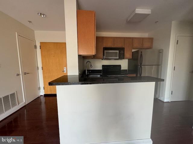 3750 Main Street, Unit 509 Philadelphia, PA 19127 - Photo 10 of 23 a large kitchen with stainless steel appliances a refrigerator a stove a microwave and cabinets