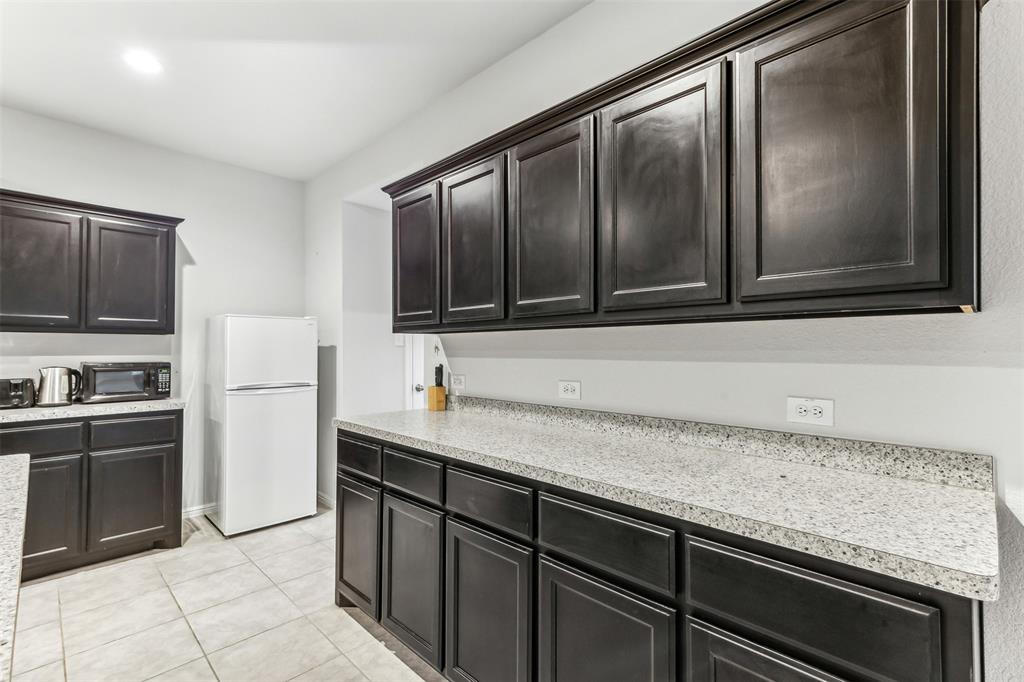 714 Wolf Creek Cleburne, TX 76033 - Photo 11 of 40 a kitchen with stainless steel appliances granite countertop a sink stove and microwave