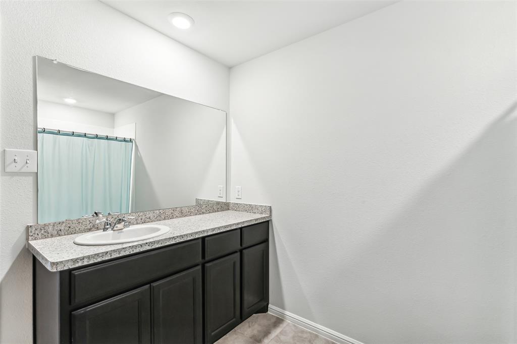 714 Wolf Creek Cleburne, TX 76033 - Photo 33 of 40 a bathroom with a granite countertop sink and a mirror
