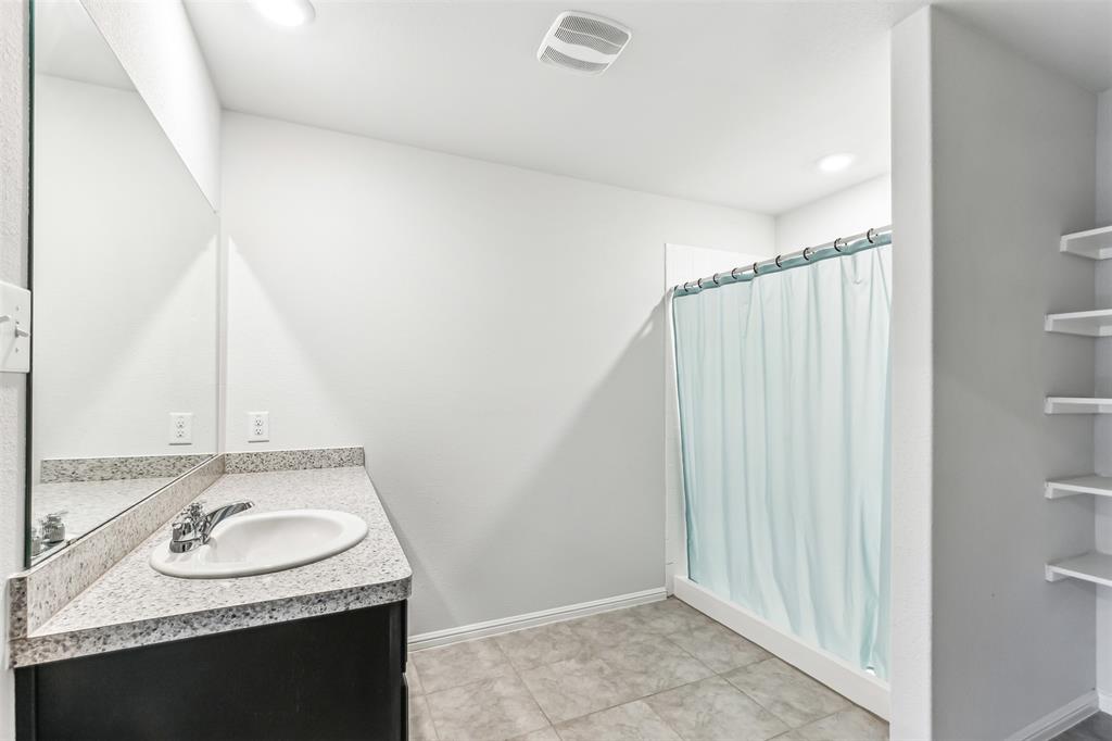 714 Wolf Creek Cleburne, TX 76033 - Photo 34 of 40 a bathroom with a granite countertop sink and a mirror