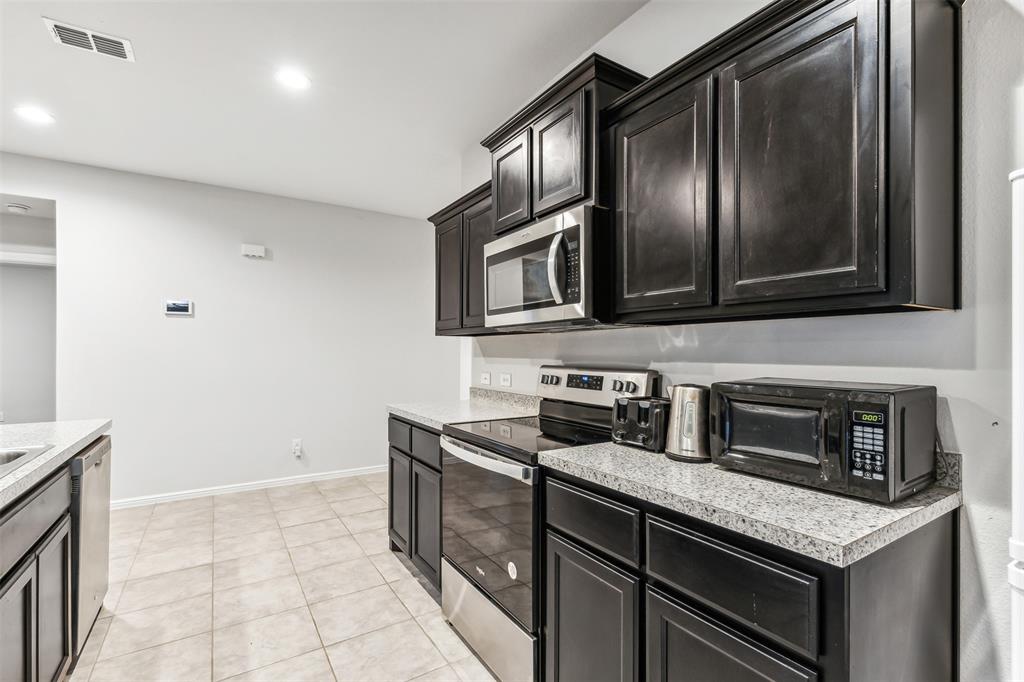 714 Wolf Creek Cleburne, TX 76033 - Photo 9 of 40 a kitchen with granite countertop stainless steel appliances and cabinets