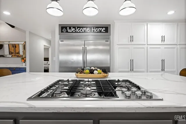 a kitchen with kitchen island granite countertop a sink stove and refrigerator