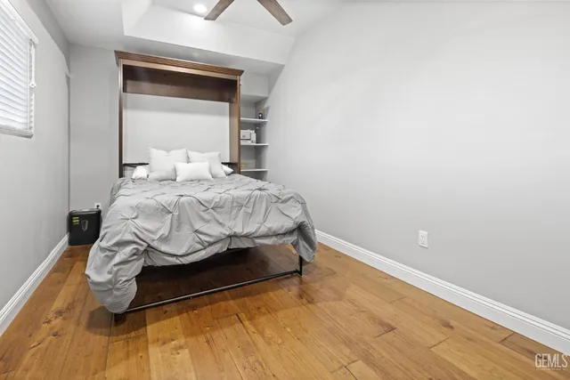 a large bed sitting in a bedroom next to a window and a chandelier