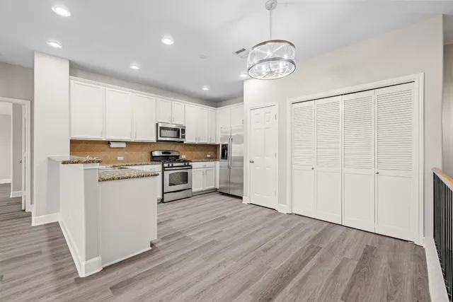 a view of a kitchen with a wooden floor and a kitchen