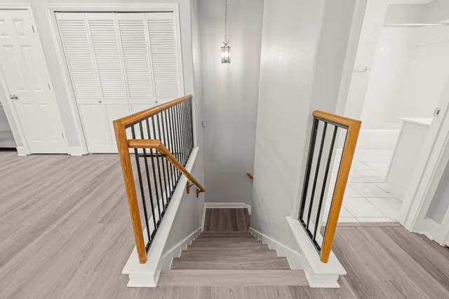 a view of a hallway with wooden floor and staircase