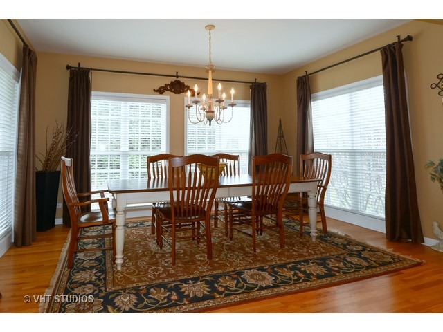 756 Ridge Drive Elburn, IL 60119 - Photo 4 of 18 a dining room with furniture a chandelier and wooden floor