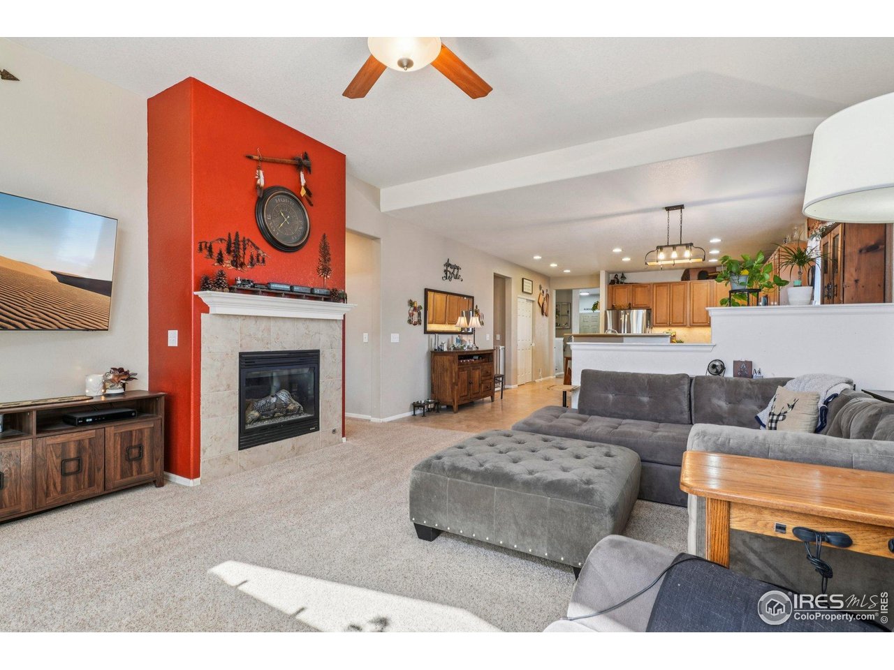 256 Homestead Way Brighton, CO 80601 - Photo 15 of 42 a living room with furniture a fireplace and a flat screen tv