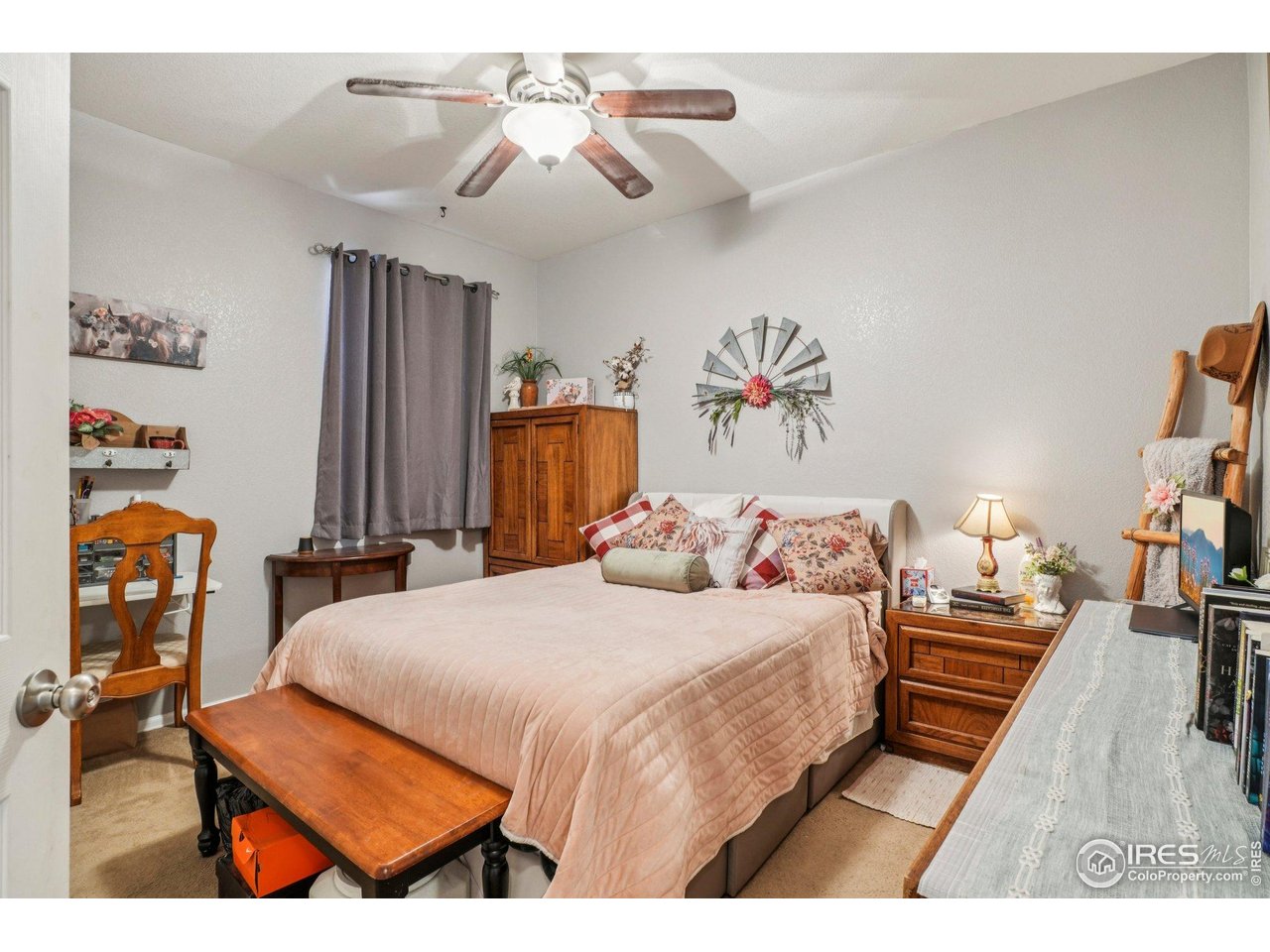 256 Homestead Way Brighton, CO 80601 - Photo 21 of 42 a bedroom with a bed and a chandelier