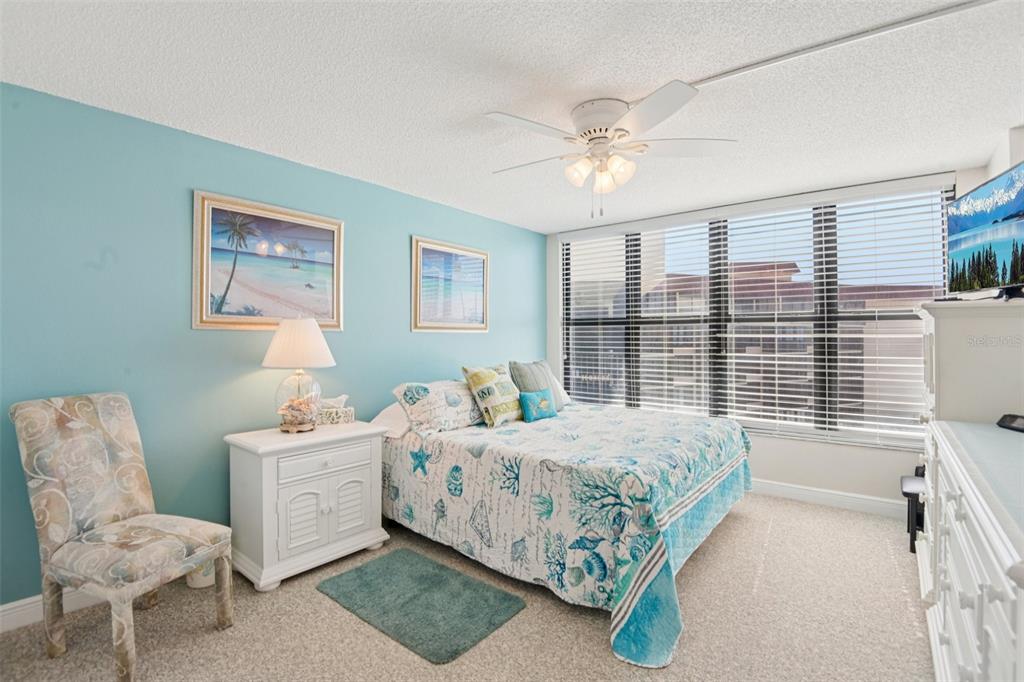 18304 Gulf Boulevard, Unit 607 Redington Shores, FL 33708 - Photo 12 of 30 a bedroom with a bed chair and a large window