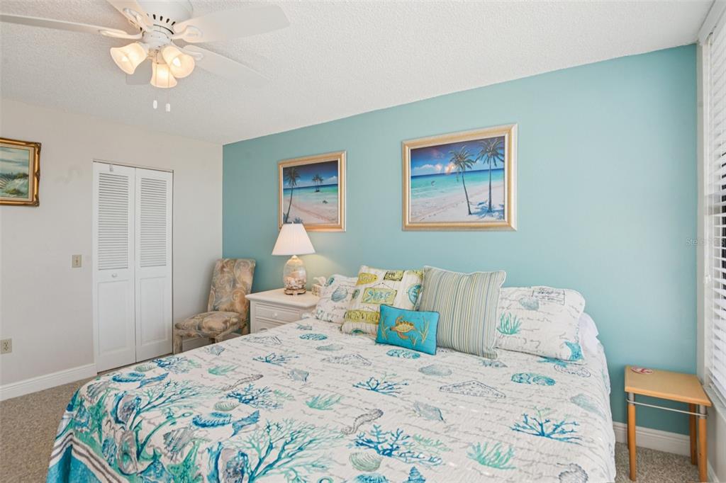18304 Gulf Boulevard, Unit 607 Redington Shores, FL 33708 - Photo 13 of 30 a bedroom with a bed and a chandelier
