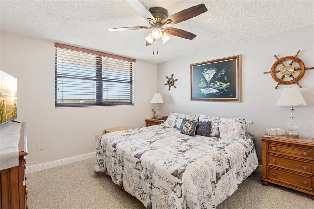 18304 Gulf Boulevard, Unit 607 Redington Shores, FL 33708 - Photo 15 of 30 a bedroom with a bed and a chandelier