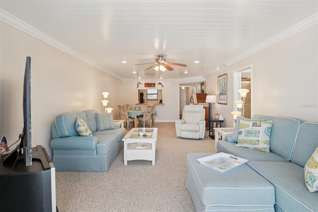 18304 Gulf Boulevard, Unit 607 Redington Shores, FL 33708 - Photo 6 of 30 a living room with furniture and a chandelier