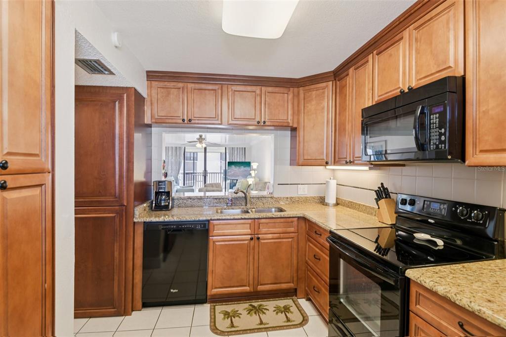 18304 Gulf Boulevard, Unit 607 Redington Shores, FL 33708 - Photo 9 of 30 a kitchen with a sink stove top oven and cabinets