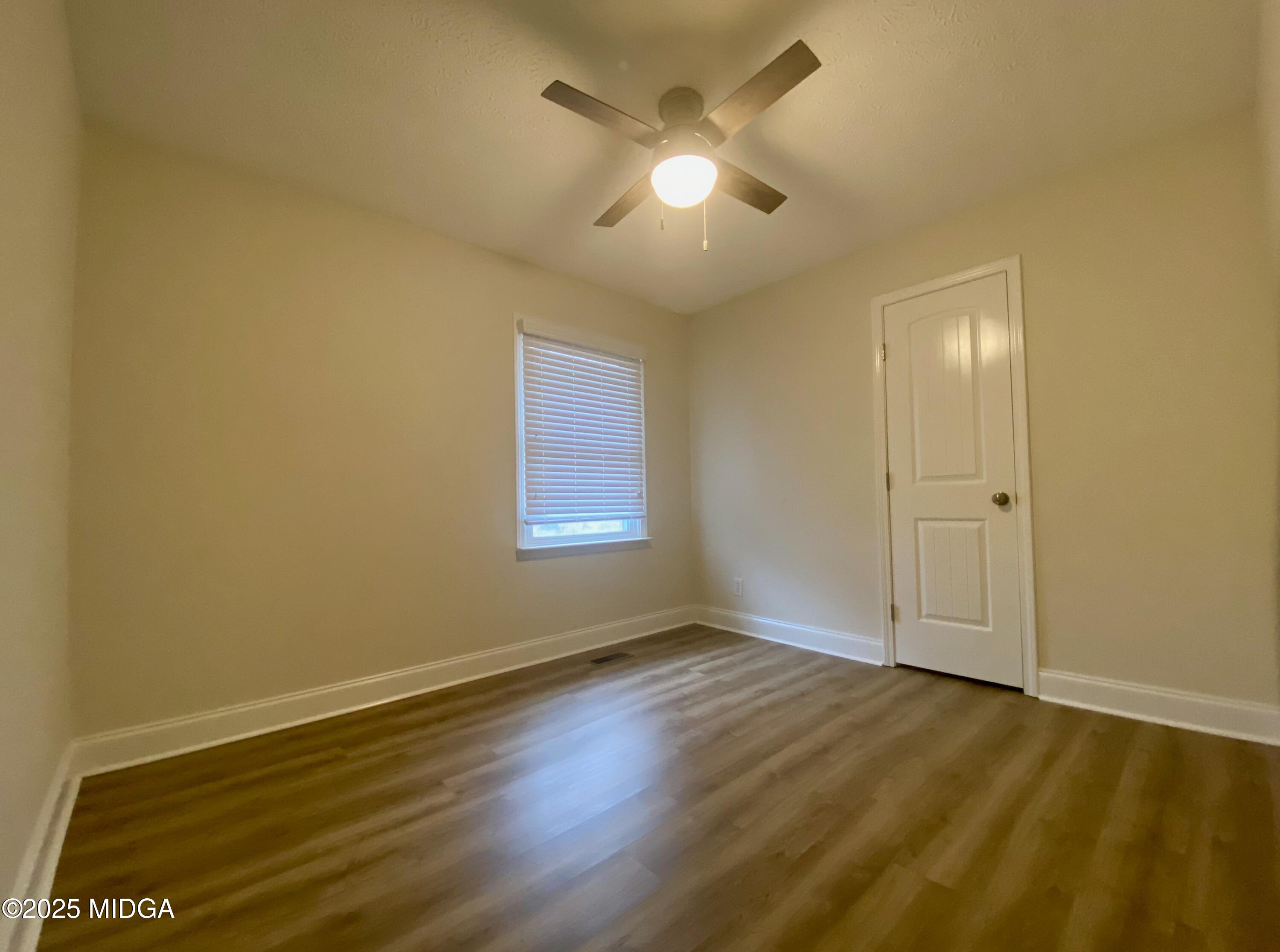 727 Walker Road Byron, GA 31008 - Photo 7 of 23 an empty room with wooden floor and windows