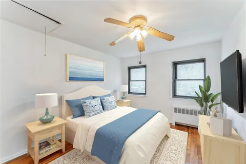 a bedroom with a bed and a flat tv screen on dresser