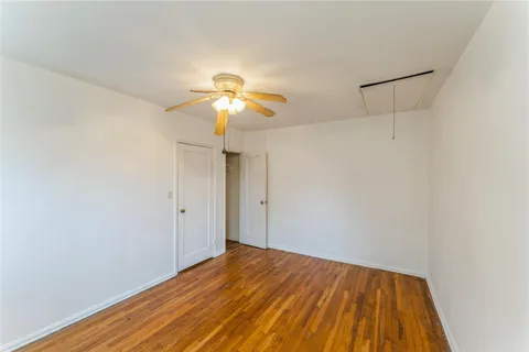 a view of a room with wooden floor and a ceiling fan