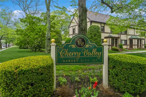 a sign of golf club on a wall under a tree