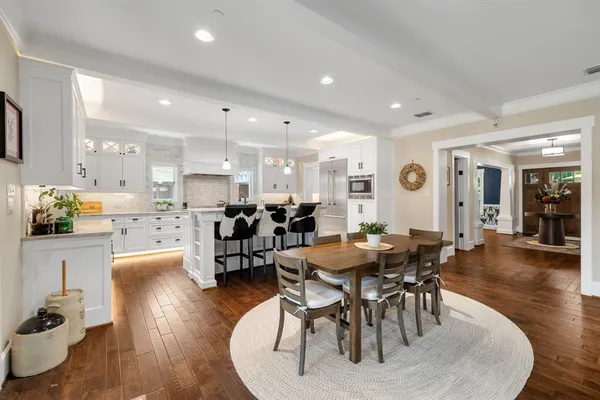 a large kitchen with dining table chairs and living room