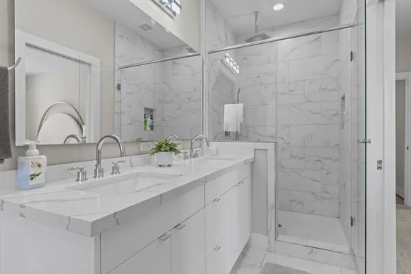 a bathroom with a double vanity sink mirror and shower