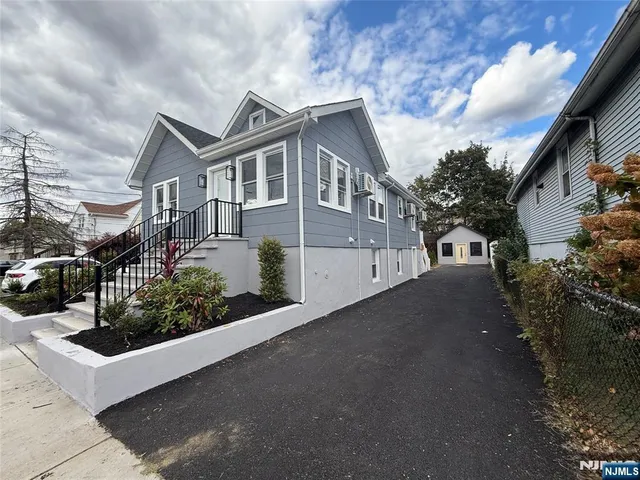 a front view of a house with plants and garage