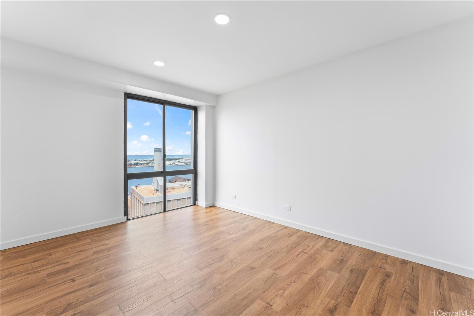 700 Richards Street, Unit 1709 Honolulu, HI 96813 - Photo 13 of 25 a view of an empty room with wooden floor and a window