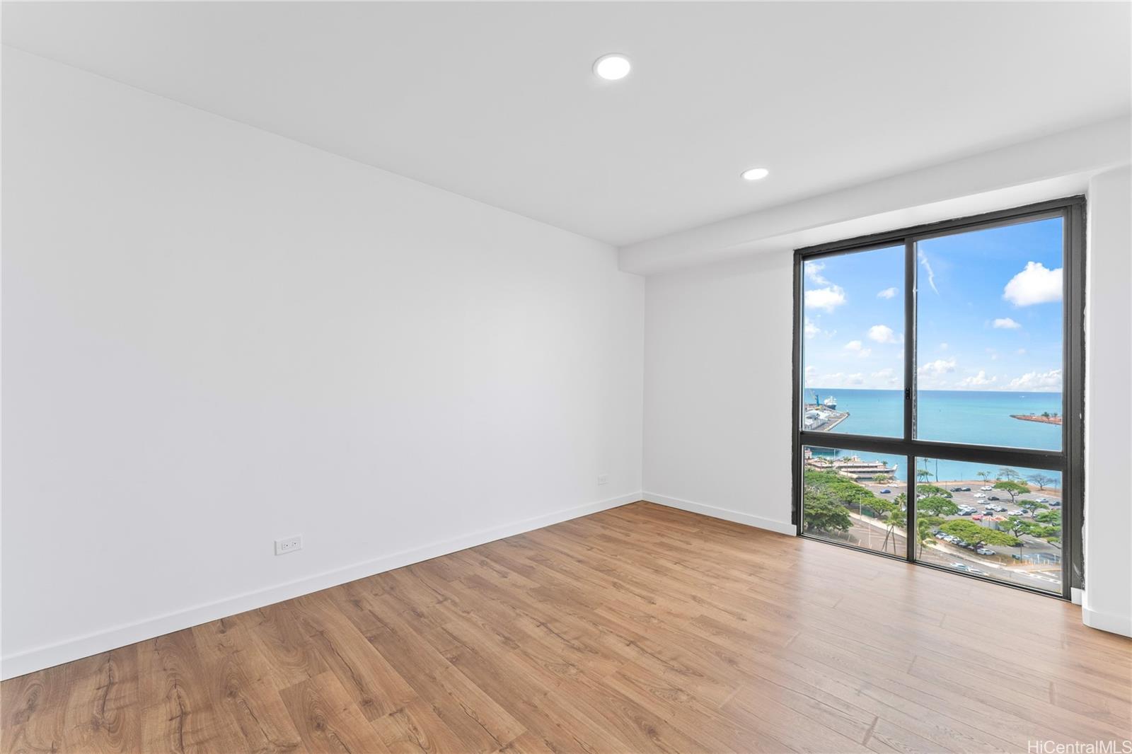 700 Richards Street, Unit 1709 Honolulu, HI 96813 - Photo 14 of 25 an empty room with wooden floor and windows