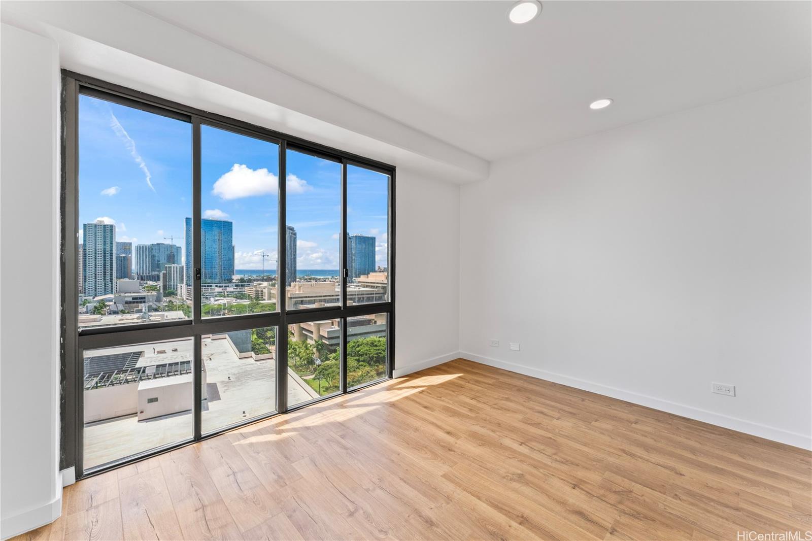 700 Richards Street, Unit 1709 Honolulu, HI 96813 - Photo 18 of 25 a view of empty room with wooden floor and fan
