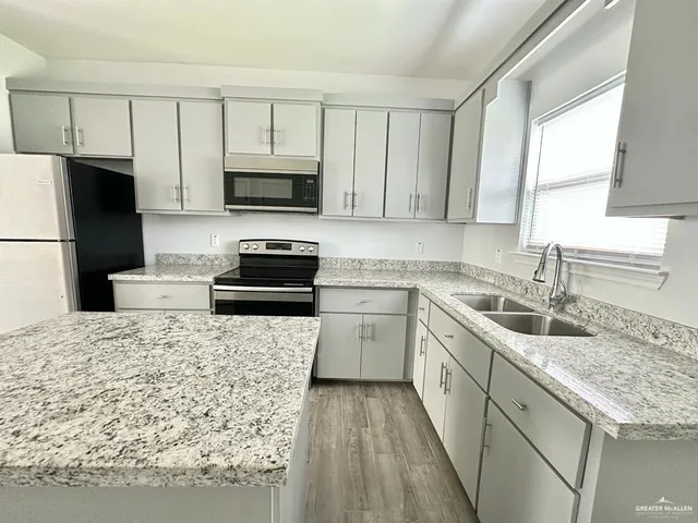 a kitchen with a sink stove and refrigerator