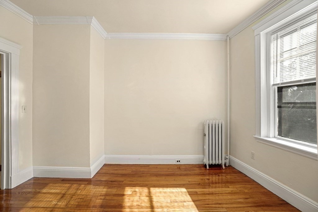 55 Lanark Road, Unit 6 Boston, MA 02135 - Photo 6 of 12 a view of an empty room with wooden floor and a window