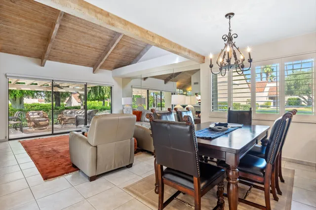 a dining room with furniture a chandelier and pool table