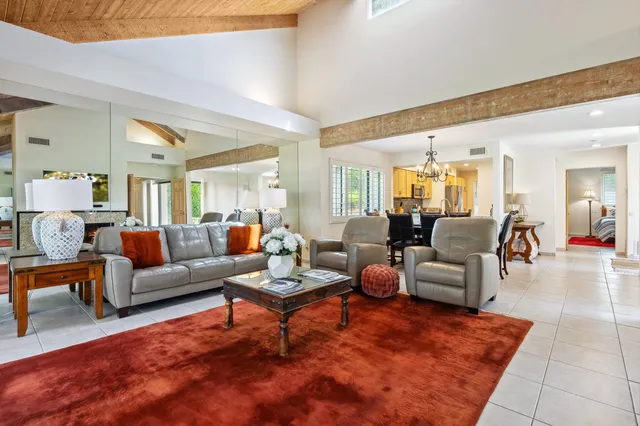 a living room with furniture a rug and a dining table