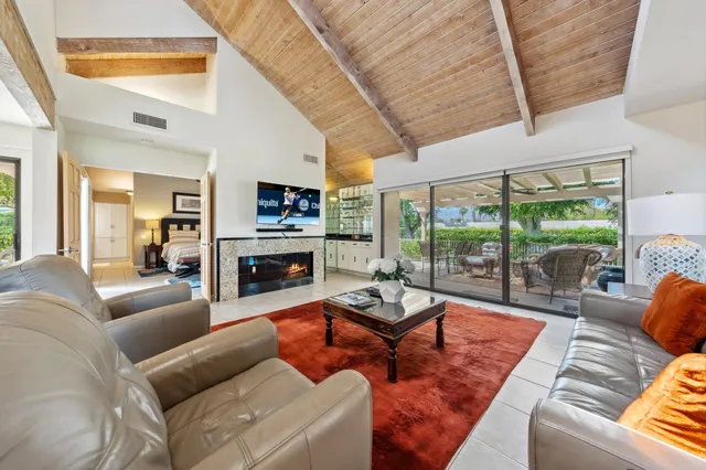 a living room with furniture fireplace and a large window