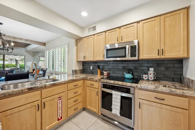 a kitchen with appliances a sink and cabinets