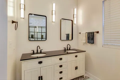 a bathroom with double sink and two mirror