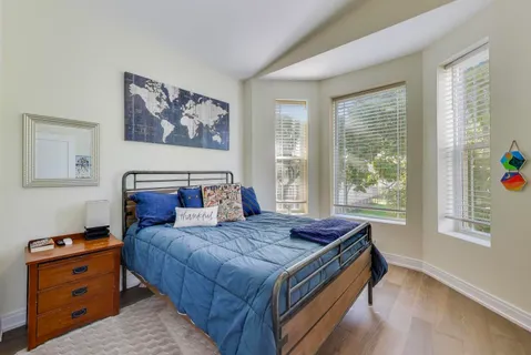 a bed sitting in a bedroom next to a window