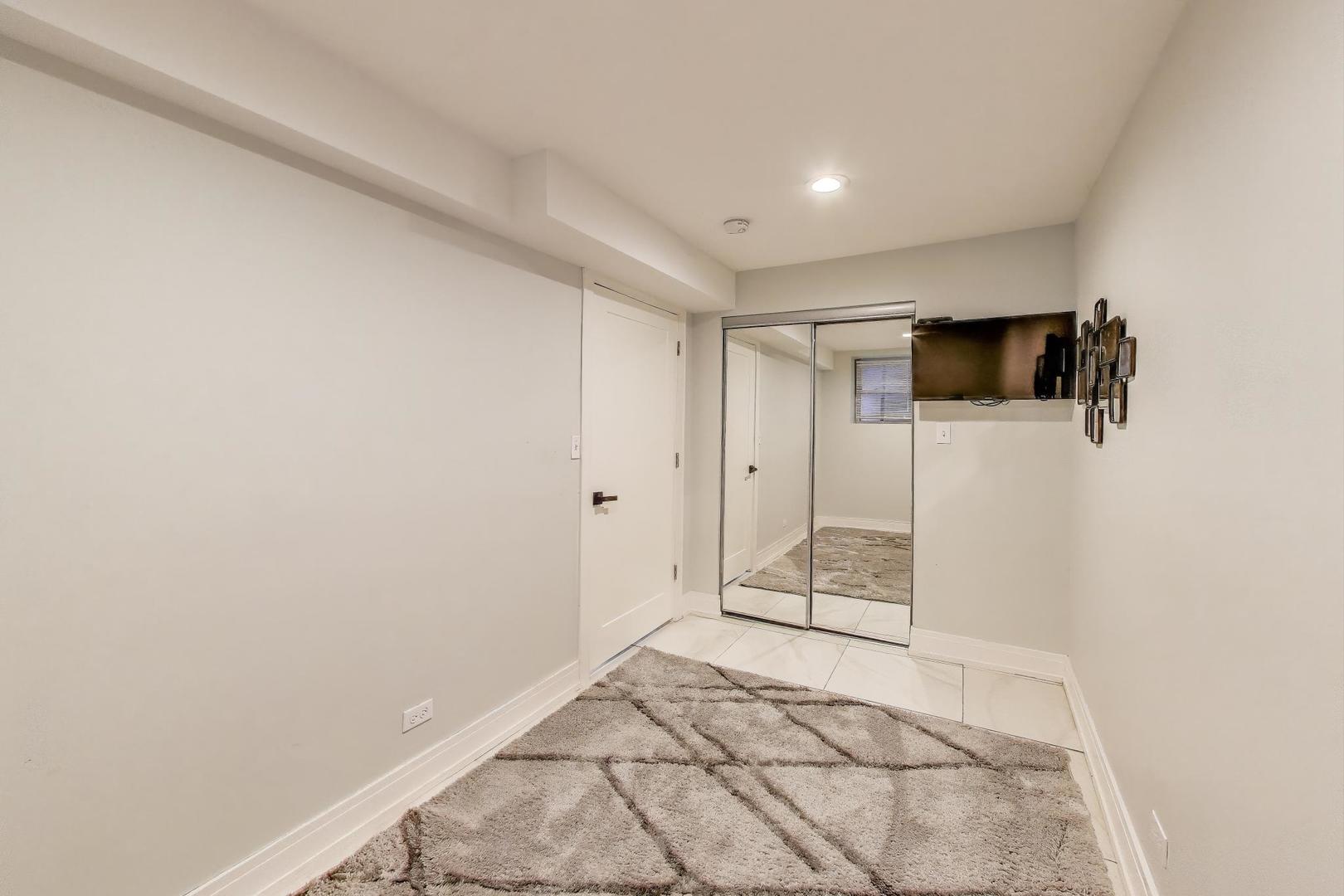 6511 South Evans Avenue Chicago, IL 60637 - Photo 23 of 30 a view of a livingroom with wooden floor and a flat screen tv