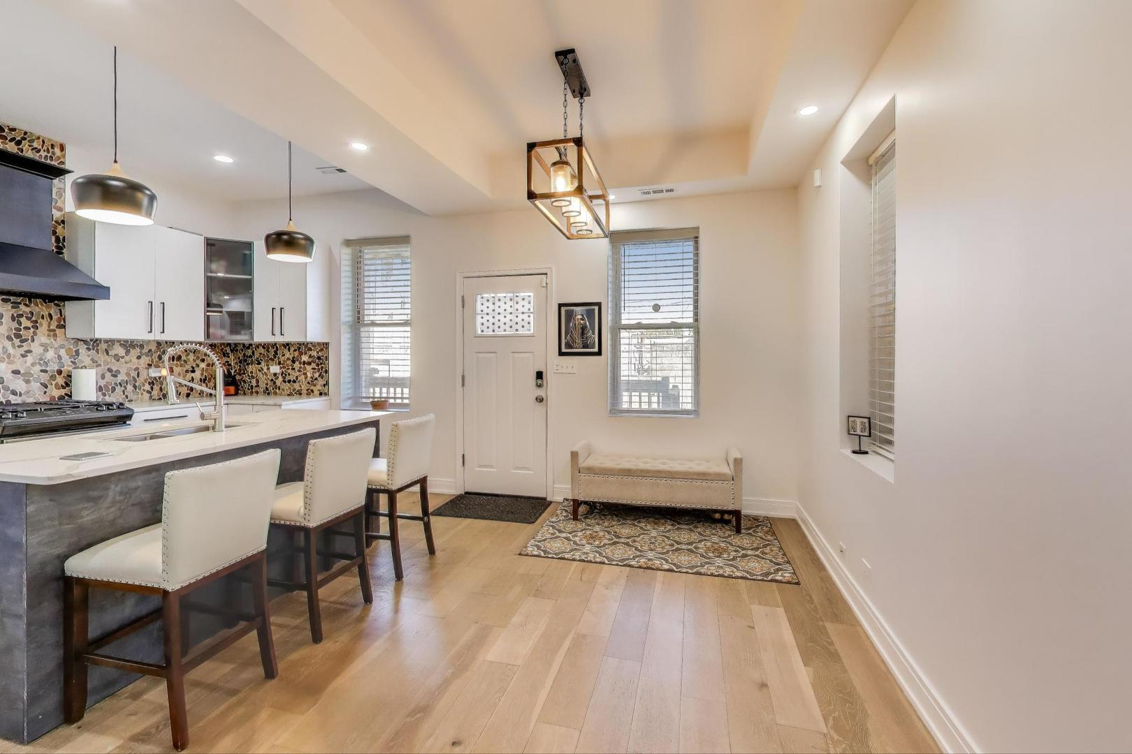 6511 South Evans Avenue Chicago, IL 60637 - Photo 9 of 30 a view of a kitchen with kitchen island stainless steel appliances wooden floor dining table and chairs